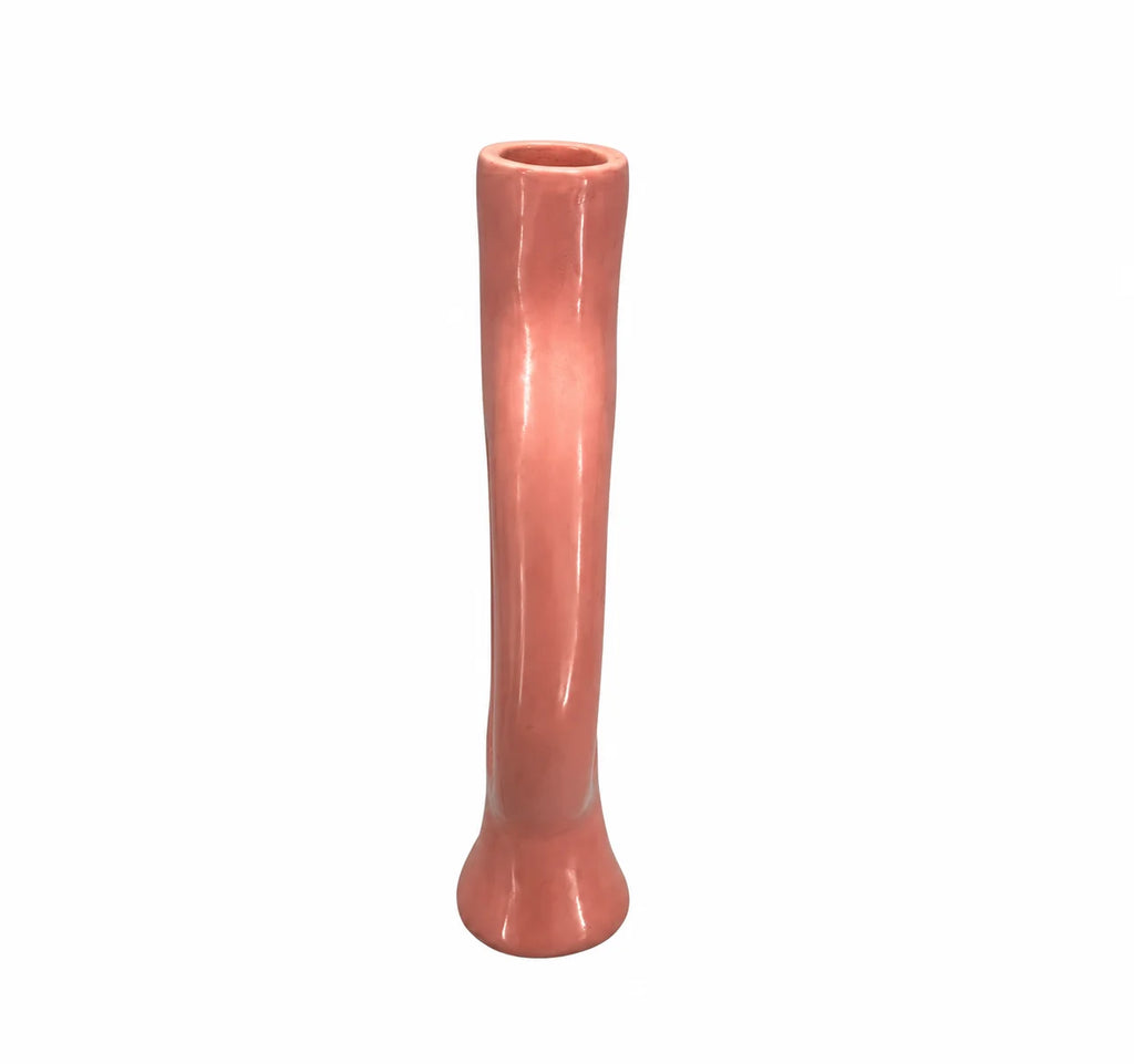A tall, slender ceramic vase with a glossy finish, featuring a flared base and a slightly tapered, wavy silhouette in a warm coral pink color, isolated on a white background.