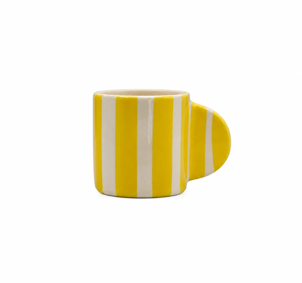 A ceramic coffee mug with a bright yellow and white vertical stripe pattern, featuring a unique rounded handle on the right side, shown against a plain white background.