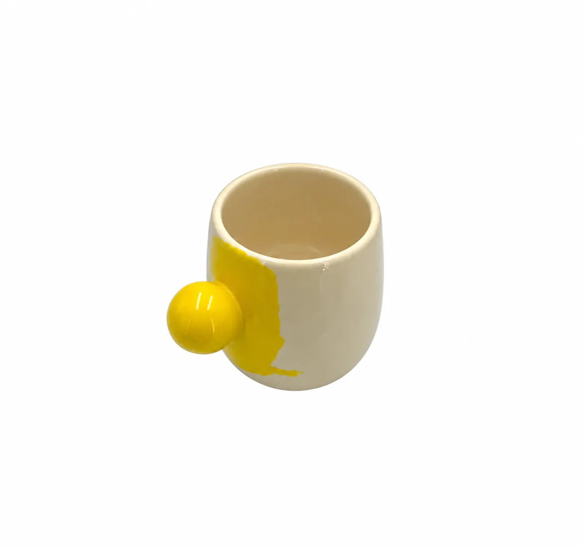 A ceramic egg-shaped mug with a cream-colored body and a bright yellow side accent resembling a cracked egg yolk, shown on a plain white background.