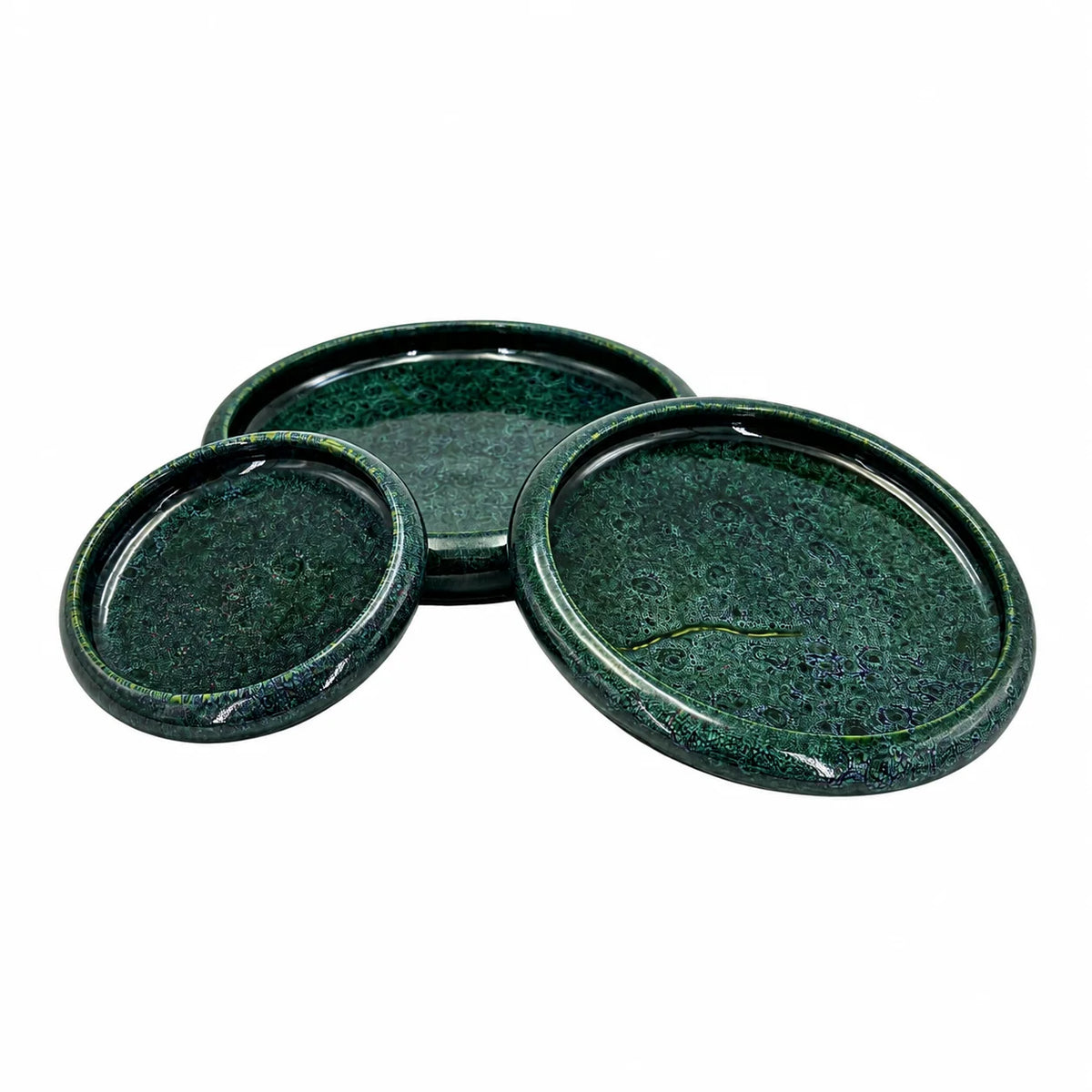 Three round dark green ceramic coasters with a textured, speckled glaze, arranged on a plain white background.